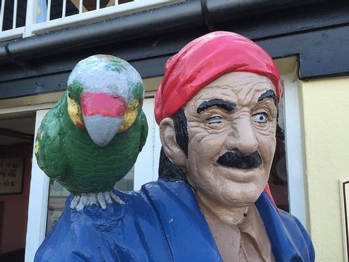 Plastic statue of a pirate with a parrot on his shoulder.