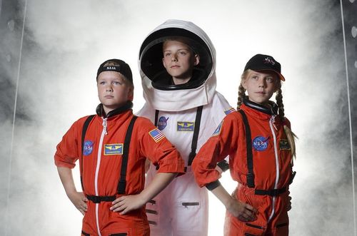 Three kids dressed as astronauts on a visit to the National Space Centre in Leicester.