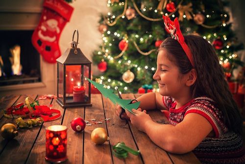 A girl making Christmas decorations at home.