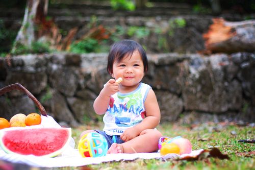 Small child snacking on fruit at a picnic