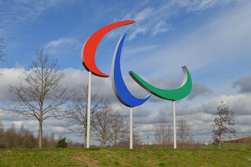 The Paralympic logo, featuring a red, blue and green curve, standing on a green hill
