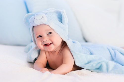 A newborn baby wearing blue teddy cape