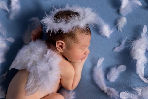 An angel newborn baby with wings and halo sleeping