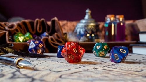 colorful d20 dice on strategy paper and leather pouch