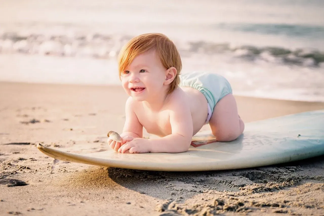 A happy baby boy on surfboard