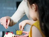  Mère et fille décorant un gâteau de pirate avec des pépites.